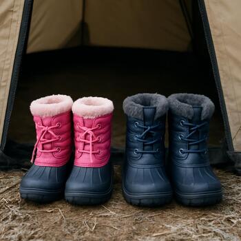 Small winter boots and mittens lined up by the door