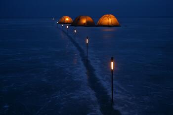 Reflective markers along a snowy trail back to shore