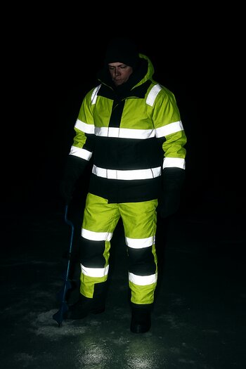 Ice anglers wearing reflective clothing glowing in headlamp beams